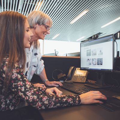 To kvinder kigger på computerskærm på kontor
