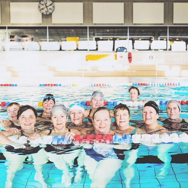 En flok kvinder i pensionsalder hygger sig i svømmehallen
