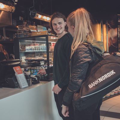 To unge mennesker betaler med kort i en café