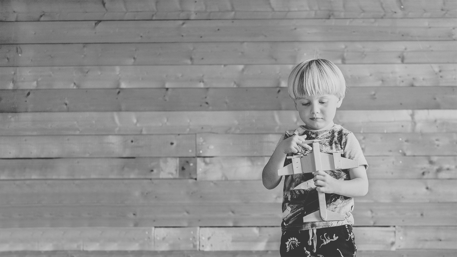 Sort hvidt billede af lille dreng med en legetøjsflyver